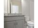Modern bathroom with grey vanity, granite countertops, and a toilet in the shower/tub space at 1117 Cordia Ave, Atlanta, GA 30318