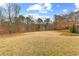 Large backyard with expansive grassy area and wooded perimeter offers privacy and space at 1452 Redwine Rd, Fayetteville, GA 30215