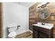 Modern bathroom with wood accent wall, vanity and toilet at 1452 Redwine Rd, Fayetteville, GA 30215