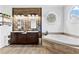 Elegant bathroom featuring double sinks, a soaking tub, and natural wood finishes at 1452 Redwine Rd, Fayetteville, GA 30215