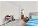 Well-lit bedroom with a blue quilt, a storage unit, and a glimpse into the bathroom at 1452 Redwine Rd, Fayetteville, GA 30215