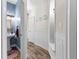 Inviting hallway with wainscoting, and decorative archway detail leading to a bathroom, and hardwood flooring at 1452 Redwine Rd, Fayetteville, GA 30215