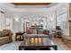 Open floor plan living room with coffered ceiling, stone fireplace, and view to kitchen at 1452 Redwine Rd, Fayetteville, GA 30215