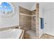 Modern shower with tiled walls, glass enclosure, and natural light from an octagonal window at 1452 Redwine Rd, Fayetteville, GA 30215