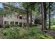 Multi-story home surrounded by tall trees, plants, chairs, and lawn at 170 Elysian Nw Way, Atlanta, GA 30327