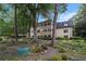 Multi-story home with a dark roof, surrounded by lawn, tall trees, plants and stone at 170 Elysian Nw Way, Atlanta, GA 30327