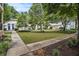 Lush courtyard featuring manicured lawns, mature trees, and walkway leading to apartment building entrances with blue doors at 2230 Cheshire Bridge Ne Rd # 401, Atlanta, GA 30324