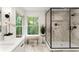Bright bathroom with glass enclosed shower, marble tile, a bench near the window, and modern fixtures at 2855 Lamer Trce, Marietta, GA 30066