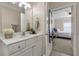 Bathroom featuring white cabinets, mirror, and doorway view into the bedroom at 1850 Cotillion Drive # 2118, Dunwoody, GA 30338