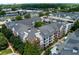 View of luxury condominium building with brick and beige siding, featuring balconies, roof detail and mature trees at 1850 Cotillion Drive # 2118, Dunwoody, GA 30338