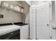 Functional laundry room with modern washer and dryer, shelving for storage, and a door for easy access at 1850 Cotillion Drive # 2118, Dunwoody, GA 30338