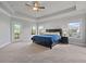 Spacious bedroom with trey ceiling, carpet, a large bed and two windows that let in natural light at 2050 Poplar Ridge Pl, Cumming, GA 30040