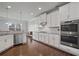 Modern white kitchen featuring stainless steel appliances, granite countertops, and ample cabinet space at 2050 Poplar Ridge Pl, Cumming, GA 30040