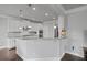An open kitchen with white cabinets, granite countertops, and stainless steel appliances offers a modern aesthetic at 2050 Poplar Ridge Pl, Cumming, GA 30040