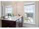 Bathroom featuring a sink with marble countertop, dark cabinets, and a large window that provides natural light at 2367 Millhaven Se St, Smyrna, GA 30080
