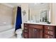 Bathroom with bathtub-shower combo featuring a dark blue shower curtain, vanity with white countertop, and dark cabinets at 2367 Millhaven Se St, Smyrna, GA 30080