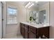 Bathroom featuring double sinks, a vanity with a white countertop and dark wood cabinets, a large mirror, and natural light at 2367 Millhaven Se St, Smyrna, GA 30080