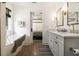 Bright bathroom features a dual sink vanity, bathtub, and entrance to main bedroom at 3135 Bluebird Ln, Decatur, GA 30032
