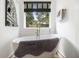 Bright bathroom features a freestanding tub, gold fixtures, and large window at 3135 Bluebird Ln, Decatur, GA 30032