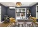 Stylish dining room featuring a modern chandelier, glass table, navy walls, and a view to the outside at 3135 Bluebird Ln, Decatur, GA 30032