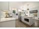 Modern white kitchen featuring stainless steel appliances, a central island, and lots of natural light at 3135 Bluebird Ln, Decatur, GA 30032