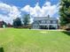 Expansive backyard with lush green lawn, large patio, play set and view of home's rear exterior at 3804 Bay Orchard Lane, Loganville, GA 30052