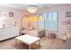 Pretty bedroom featuring light wood floors, plantation shutters, and cute decor at 3804 Bay Orchard Lane, Loganville, GA 30052