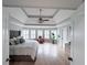 Inviting main bedroom with tray ceiling, light-filled windows, and light wood flooring at 3804 Bay Orchard Lane, Loganville, GA 30052