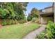 Spacious backyard with lush lawn, bordered by trees and a stepped path leading to a wooden deck at 132 Cornerstone Pl, Woodstock, GA 30188