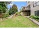Backyard with a well-maintained lawn, mature trees, and a quaint wooden staircase to the upper level at 132 Cornerstone Pl, Woodstock, GA 30188