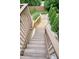 Backyard wooden stairs leading to upper level, surrounded by manicured greenery and decorative stones at 132 Cornerstone Pl, Woodstock, GA 30188