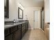 Bathroom featuring double sinks, dark wood cabinets, granite counters, and a walk-in shower at 132 Cornerstone Pl, Woodstock, GA 30188