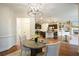 Open-concept dining area adjacent to kitchen, features stylish chandelier, wood floors, and ample space at 132 Cornerstone Pl, Woodstock, GA 30188