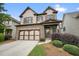 Two-story home with a stone facade and a two-car garage, complemented by manicured landscaping at 132 Cornerstone Pl, Woodstock, GA 30188