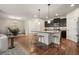 Open-concept kitchen with a central island, dark cabinets, stainless steel appliances, and hardwood floors at 132 Cornerstone Pl, Woodstock, GA 30188