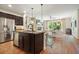 Modern kitchen featuring a center island with sink, stainless steel appliances, and seamless flow to living area at 132 Cornerstone Pl, Woodstock, GA 30188