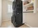 Convenient laundry area with stackable washer and dryer and storage shelves at 132 Cornerstone Pl, Woodstock, GA 30188