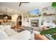 Open-concept living area with hardwood floors and fireplace and a modern kitchen in the background at 132 Cornerstone Pl, Woodstock, GA 30188