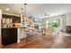 Inviting living room with hardwood floors, a stone fireplace, and an eat-in kitchen with counter seating at 132 Cornerstone Pl, Woodstock, GA 30188