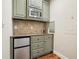 Close-up of the mini-bar with stainless steel refrigerator and overhead microwave at 132 Cornerstone Pl, Woodstock, GA 30188