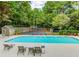 Inviting pool area with lounge chairs, complemented by a tennis court for recreation and relaxation at 3396 Misty Harbour Trl, Doraville, GA 30340