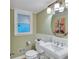 Well-lit bathroom featuring a pedestal sink, decorative mirror, and neutral decor for a clean, fresh look at 3914 Granger Dr, Atlanta, GA 30341