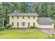 Charming two-story home with a lush lawn, attached garage, and mature trees providing ample shade at 3914 Granger Dr, Atlanta, GA 30341