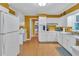 Functional kitchen featuring white appliances, a separate desk area, and hardwood floors leading to other rooms at 3914 Granger Dr, Atlanta, GA 30341