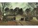 Charming single-story home with a two-car garage and mature trees surrounding the property at 791 Bristol Way, Lithonia, GA 30058