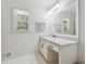 Bright bathroom featuring a white vanity with marble countertop and a large window at 190 Windflower Trce, Roswell, GA 30075
