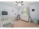 Bedroom with crib, changing table, rocker, and charming dinosaur-themed decor at 190 Windflower Trce, Roswell, GA 30075