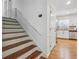 Hallway with a staircase and an open doorway to the kitchen with stainless steel refrigerator at 190 Windflower Trce, Roswell, GA 30075