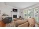 Inviting living room with a white brick fireplace, large windows, and comfortable seating area at 190 Windflower Trce, Roswell, GA 30075