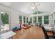 Light-filled sunroom with hardwood floors, many windows, and a door leading to a deck at 190 Windflower Trce, Roswell, GA 30075